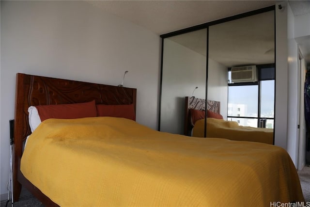 bedroom featuring a closet, carpet, and a wall mounted air conditioner