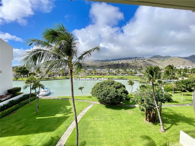 view of property's community featuring a water and mountain view and a lawn