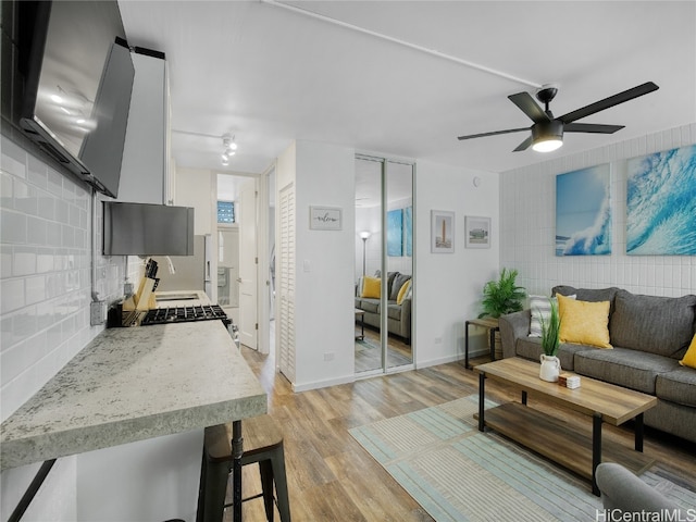 living room with ceiling fan and light wood-type flooring