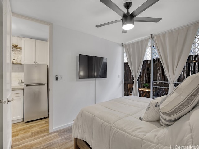 bedroom featuring light hardwood / wood-style flooring, stainless steel fridge, and ceiling fan