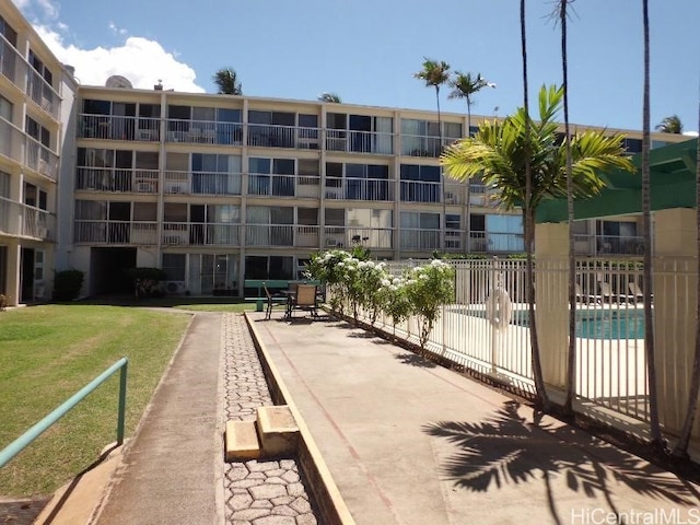 view of home's community featuring a pool and a lawn