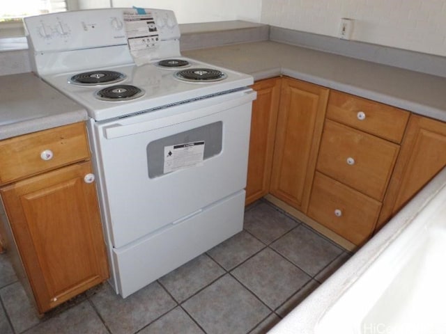 kitchen with electric range and light tile patterned flooring