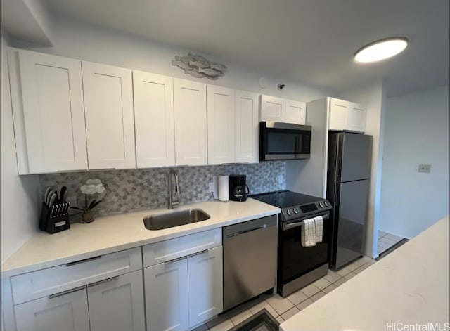 kitchen with sink, appliances with stainless steel finishes, tasteful backsplash, light tile patterned floors, and white cabinets