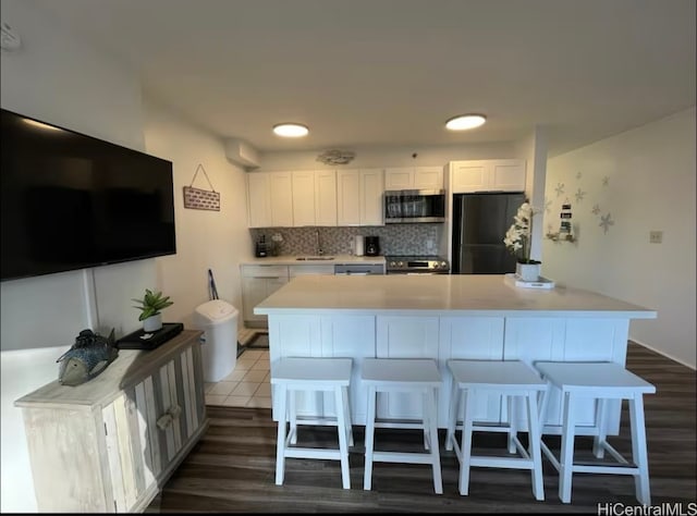 kitchen featuring white cabinetry, a center island, dark hardwood / wood-style floors, and stainless steel appliances