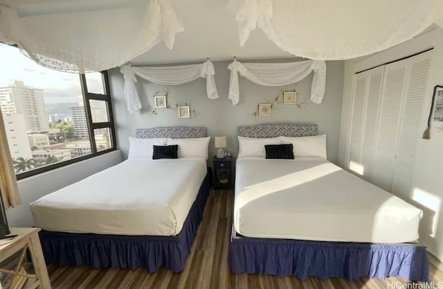 bedroom with dark hardwood / wood-style flooring and a closet