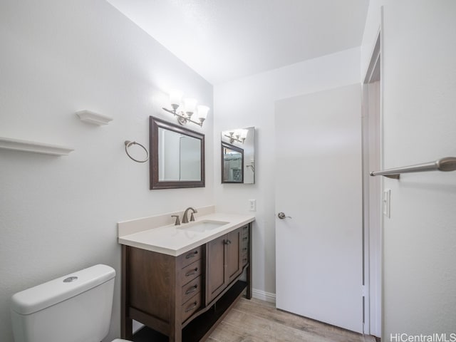 bathroom featuring vanity, toilet, and hardwood / wood-style flooring