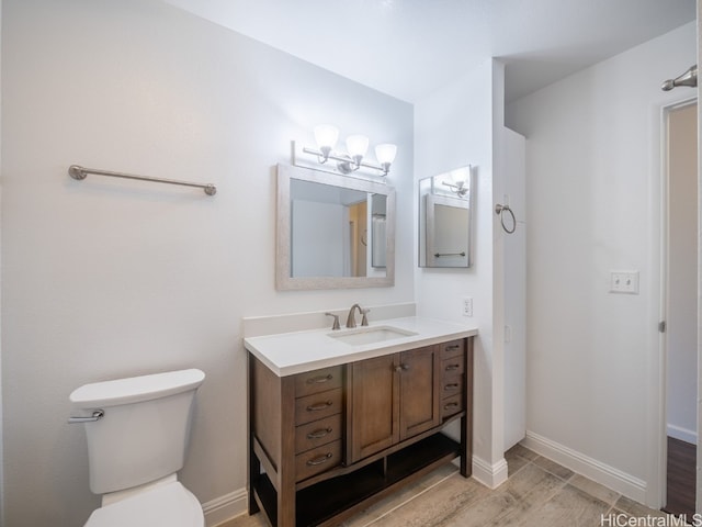 bathroom with vanity, toilet, and hardwood / wood-style floors