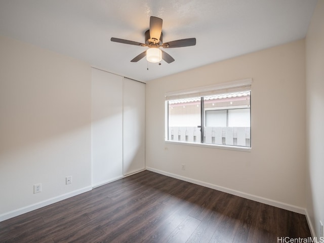 empty room featuring dark wood-type flooring and ceiling fan