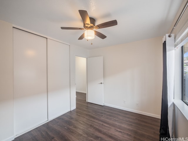 unfurnished bedroom featuring dark wood-type flooring, ceiling fan, and a closet