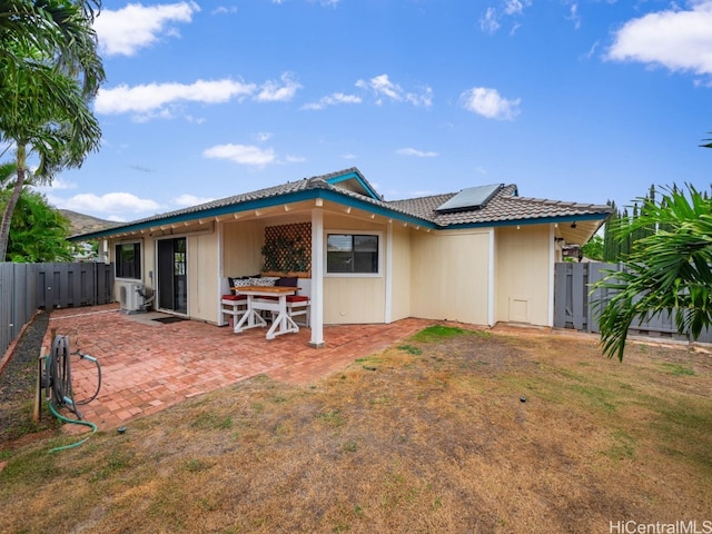 rear view of house with a patio area and solar panels