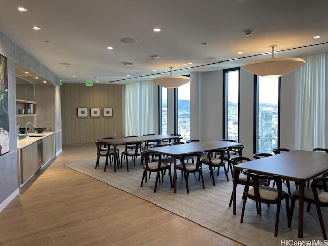 dining area with light wood finished floors, a wall of windows, and recessed lighting