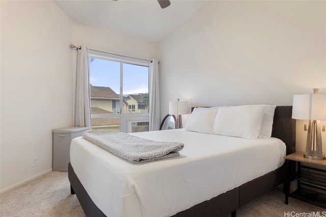 bedroom with vaulted ceiling, light colored carpet, and ceiling fan