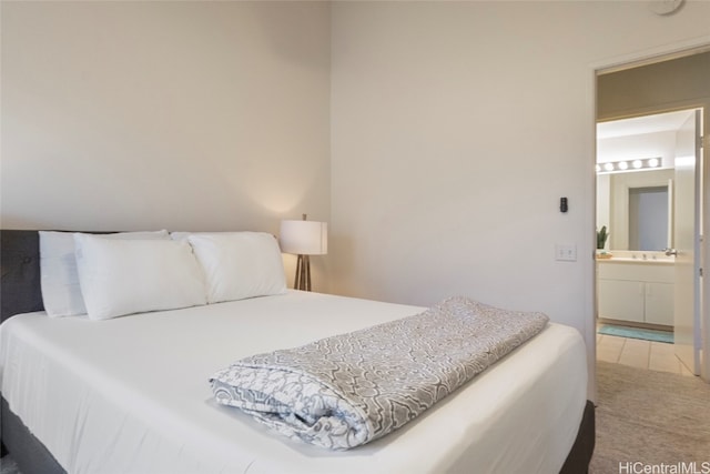 bedroom featuring connected bathroom, sink, and carpet floors