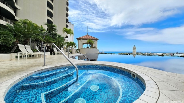 view of pool featuring a water view and a patio