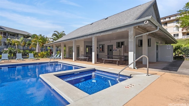 view of pool with a patio area and a hot tub