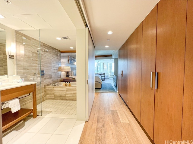 bathroom with vanity, shower with separate bathtub, and hardwood / wood-style floors