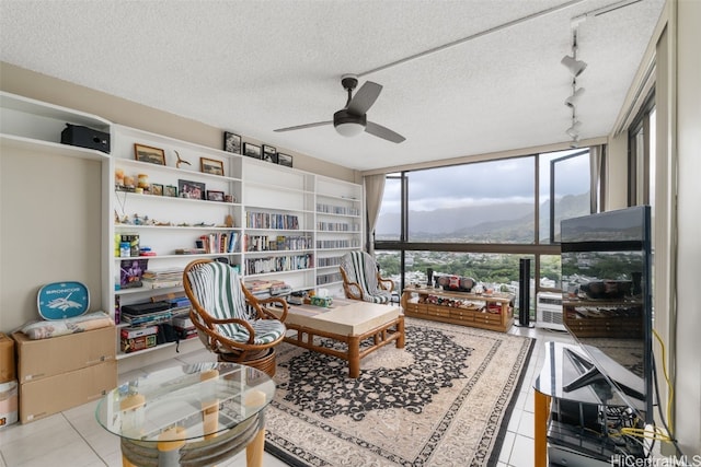 living area with track lighting, ceiling fan, light tile patterned floors, a textured ceiling, and floor to ceiling windows