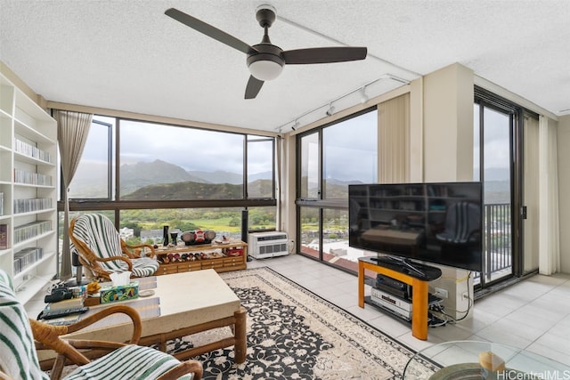 sunroom featuring rail lighting, ceiling fan, and plenty of natural light