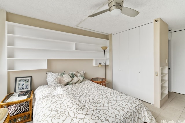 tiled bedroom featuring ceiling fan and a textured ceiling