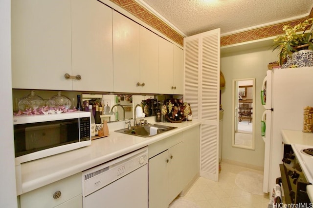 kitchen featuring sink, white cabinetry, white appliances, and a textured ceiling