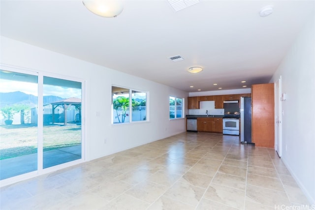 unfurnished living room featuring light tile patterned floors and sink