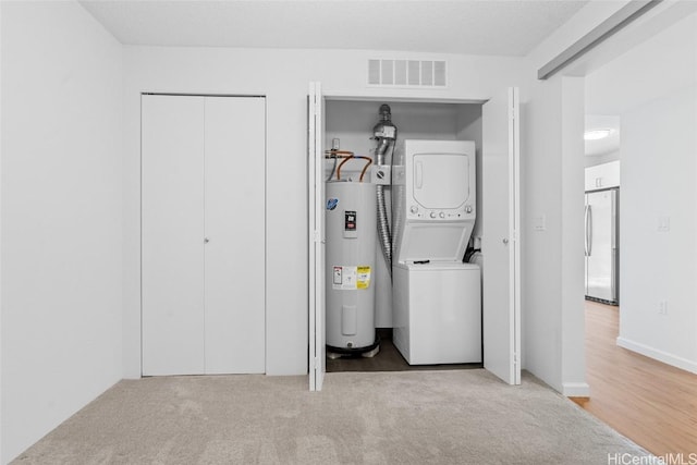 washroom featuring water heater, stacked washer and dryer, and hardwood / wood-style flooring