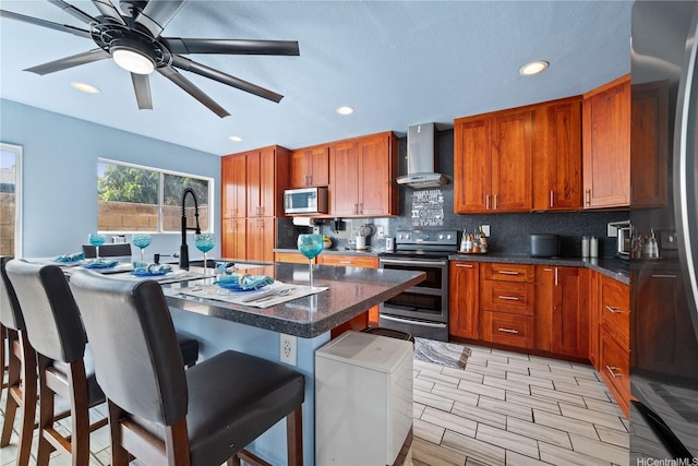 94-1420 Kahuli St, Waipahu, HI 96797 - kitchen with appliances with stainless steel finishes, wall chimney range hood, a kitchen bar, backsplash, and brown cabinets