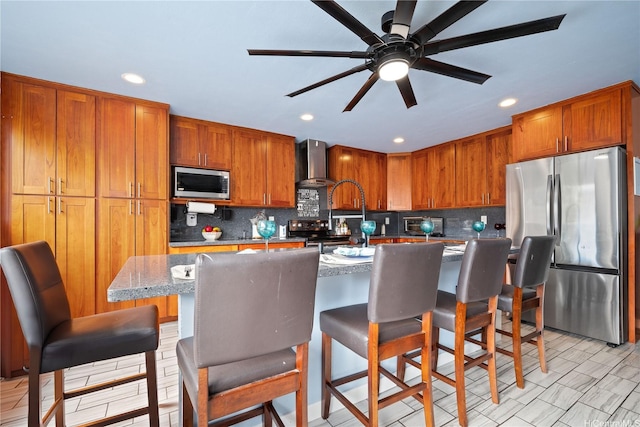 94-1420 Kahuli St, Waipahu, HI 96797 - kitchen with stainless steel appliances, wall chimney exhaust hood, backsplash, brown cabinets, and recessed lighting