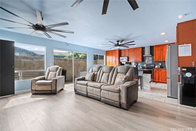 living room with ceiling fan and light wood-type flooring