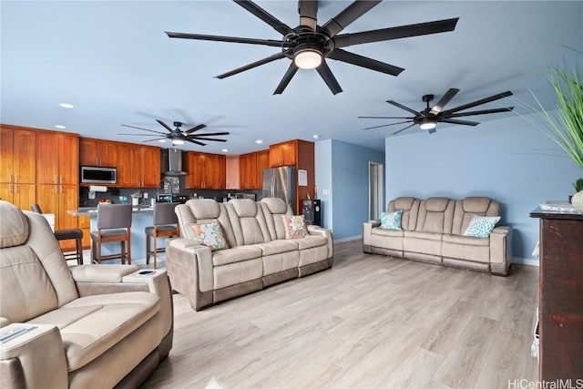 living room with ceiling fan and light hardwood / wood-style flooring