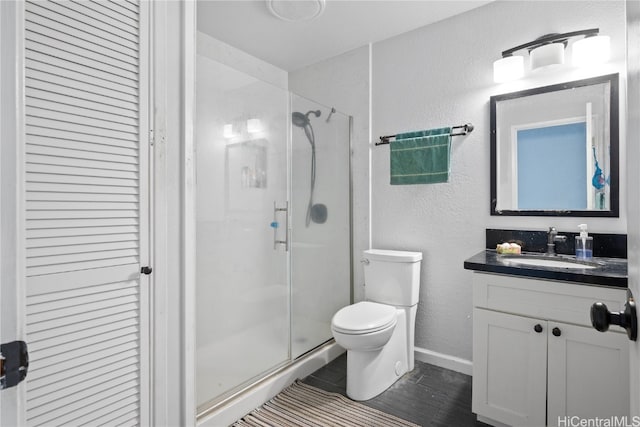 bathroom featuring an enclosed shower, vanity, and toilet