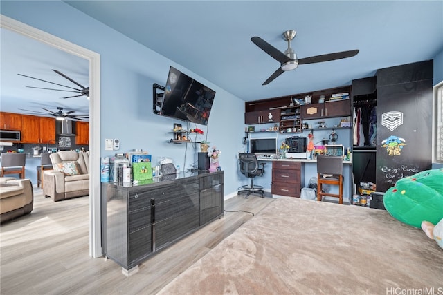 office featuring light hardwood / wood-style flooring, built in desk, and ceiling fan