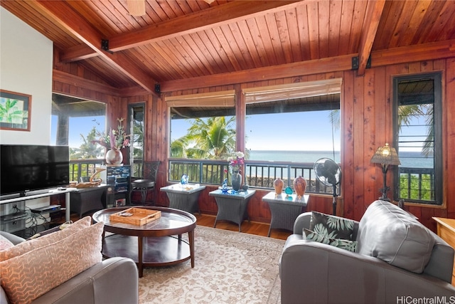 living room featuring wood ceiling, vaulted ceiling with beams, light hardwood / wood-style flooring, wooden walls, and a water view