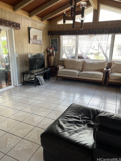 tiled living room featuring lofted ceiling with beams and wooden walls