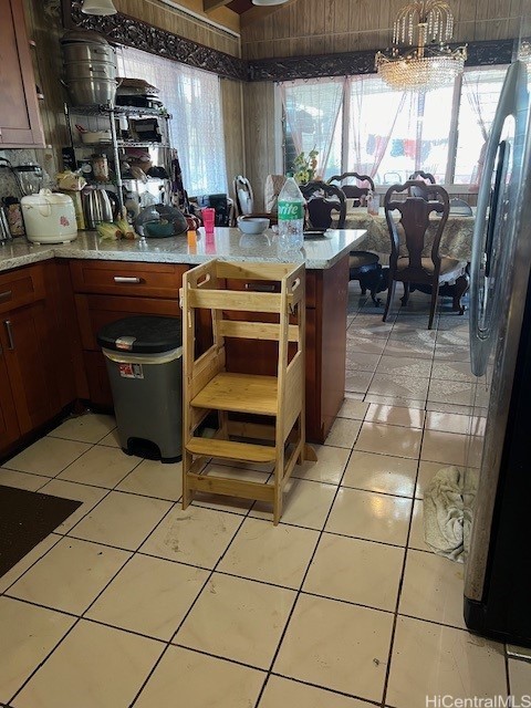 kitchen with a notable chandelier, light tile patterned floors, and stainless steel refrigerator