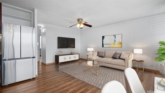 living room featuring ceiling fan, a textured ceiling, and dark hardwood / wood-style flooring