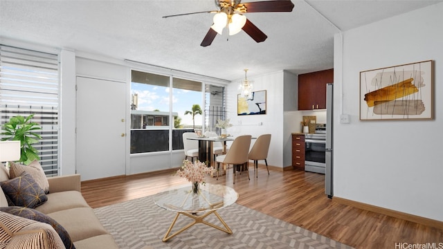 living room featuring a textured ceiling, hardwood / wood-style flooring, and ceiling fan with notable chandelier