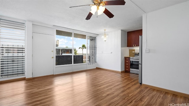 unfurnished living room featuring a textured ceiling, dark wood-type flooring, and ceiling fan with notable chandelier