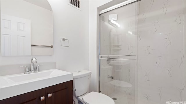 bathroom with vanity, a shower with shower door, and toilet