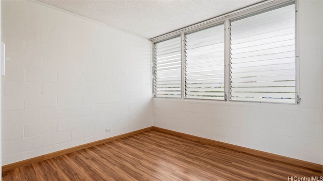 spare room featuring a textured ceiling and hardwood / wood-style flooring