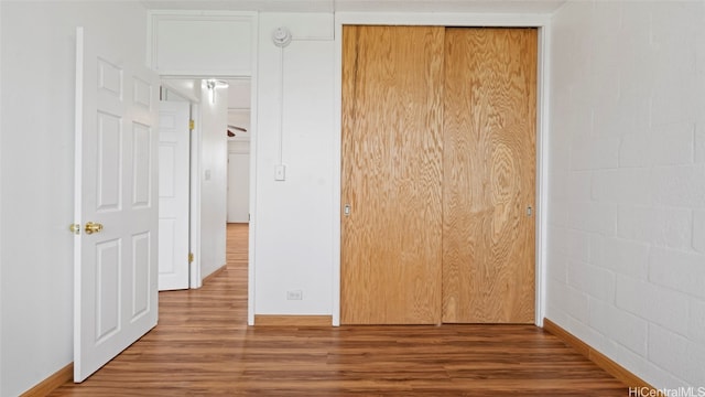 unfurnished bedroom featuring a closet and hardwood / wood-style flooring