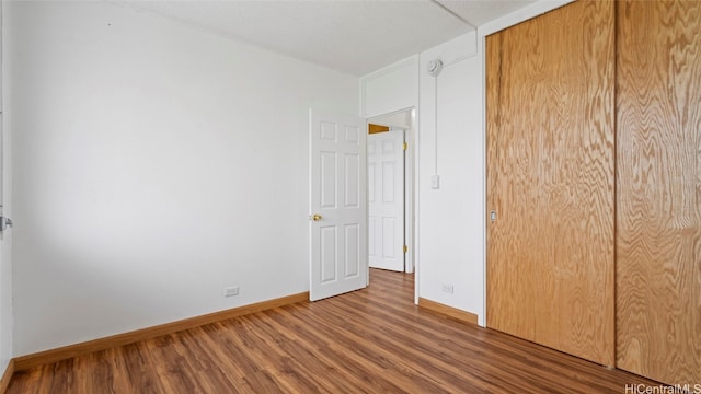 unfurnished bedroom with wood-type flooring and a closet