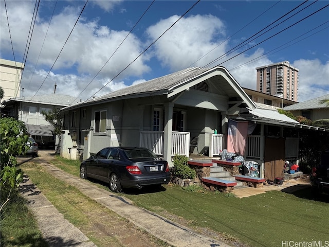 bungalow-style home with covered porch and a front yard