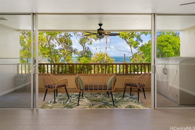 sunroom featuring a water view, ceiling fan, and plenty of natural light