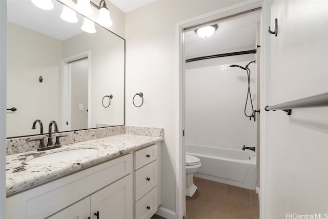 full bathroom with vanity, tiled shower / bath combo, and toilet