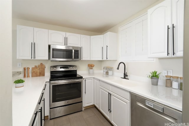 kitchen featuring white cabinets, sink, and appliances with stainless steel finishes