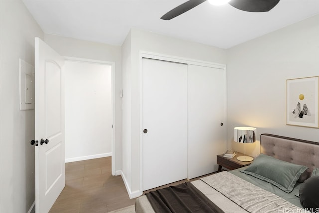 bedroom featuring light hardwood / wood-style floors, ceiling fan, and a closet