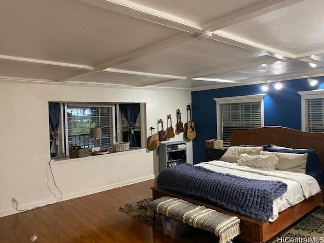 bedroom featuring dark hardwood / wood-style floors, beam ceiling, and a textured ceiling