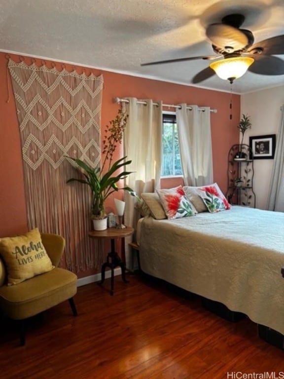 bedroom with ceiling fan, a textured ceiling, and hardwood / wood-style floors