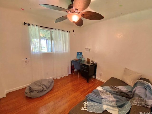 bedroom with wood finished floors, a ceiling fan, and baseboards